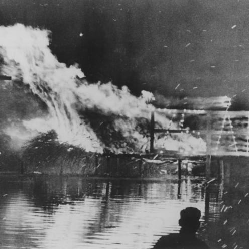 Sort-hvid foto af brændende platform i vand.