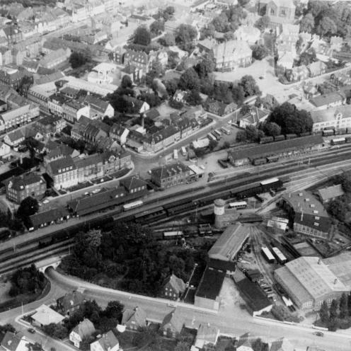 Sort-hvid luftfoto af Holbæks stationsområde og jernbanen.