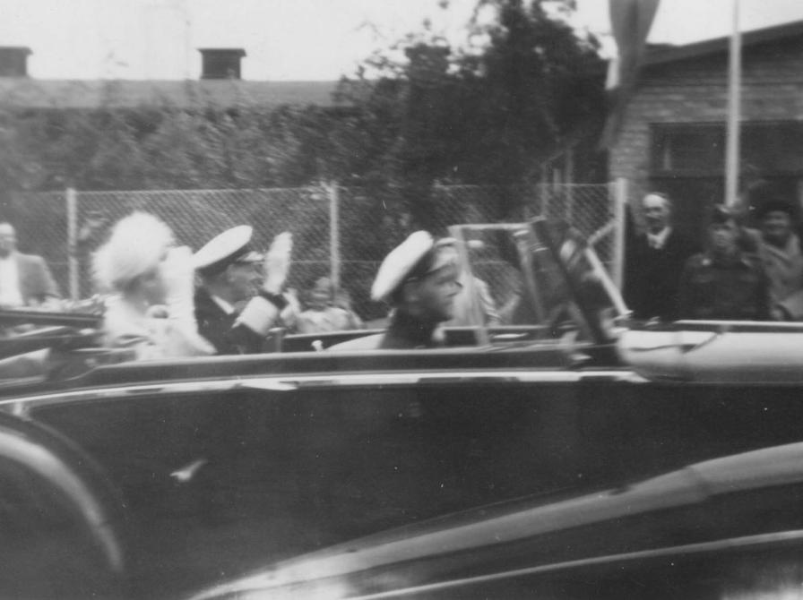 Sort-hvid foto af sort bil med Dronning Ingrid og Kong Frederik på passagersædet.